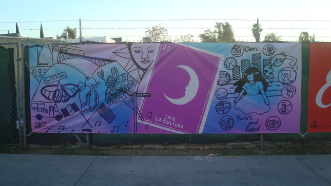 Banner on fence at a construction site on First Street. Art by Gabriella Claro, Salma Sosa, and Tatei Torres Thomas.
