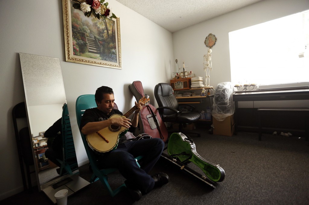 Mariachi performer Luis Valdivia practices in his apartment in Boyle Heights. Valdivia and his brother, Enrique, face eviction because they are unable to keep up with an 80% rise in rent. (Genaro Molina / Los Angeles Times) 