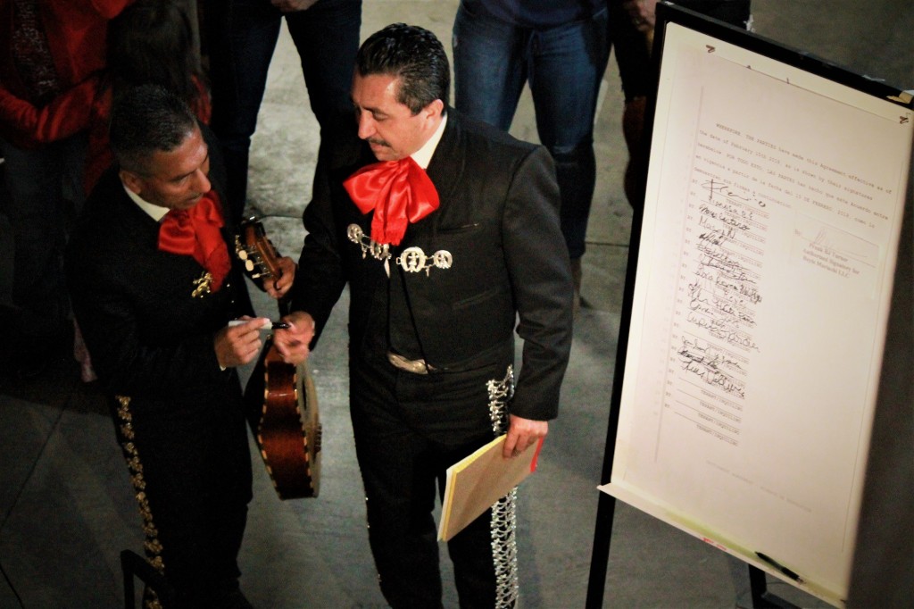 Luis and Enrique Valdivia join tenants at their Boyle Heights apartments on Feb. 15, 2018 where they signed a poster with the terms of a new contract with their landlord after a year-long fight to stay in their homes. (Nathan Solis, Courthouse News Service)